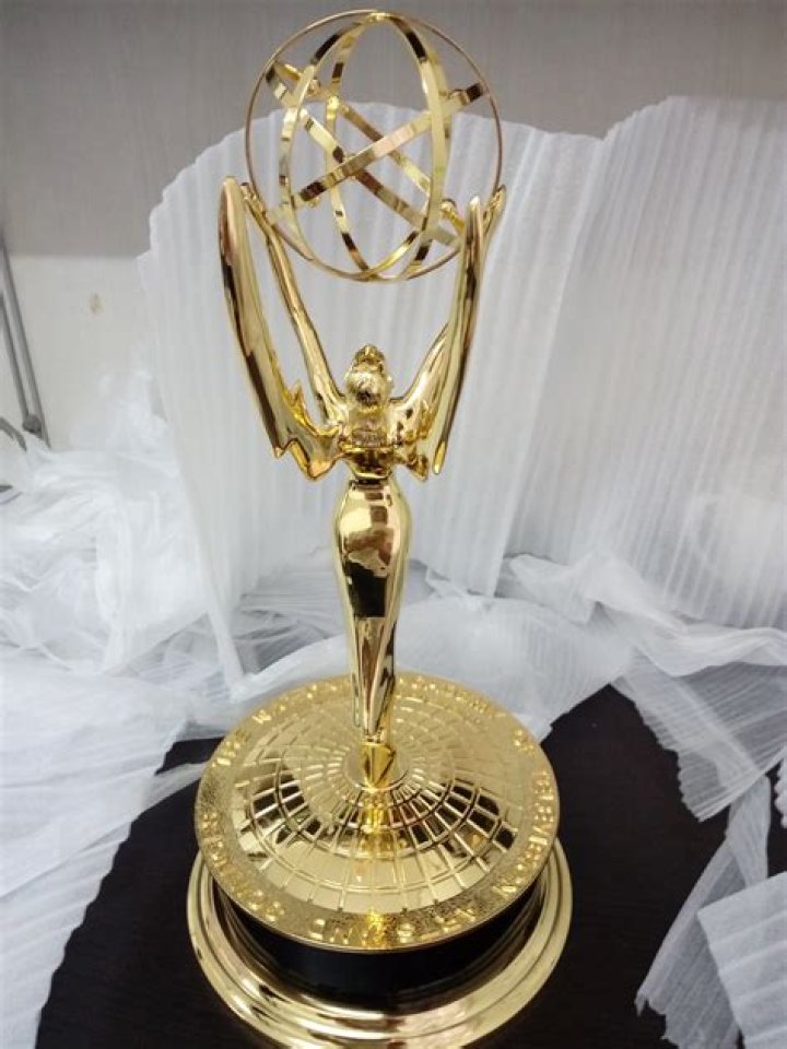 What the winged woman is holding aloft on the Emmy statuette